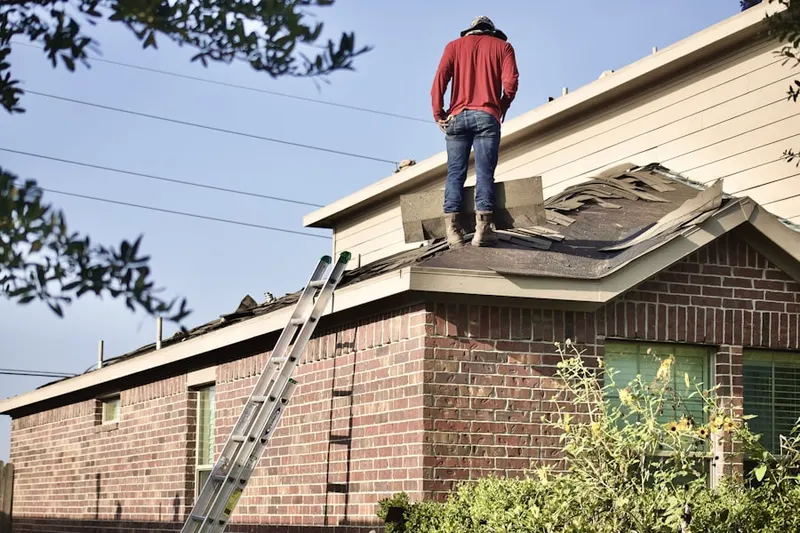 Professional roofer working on a residential roof in West Campus